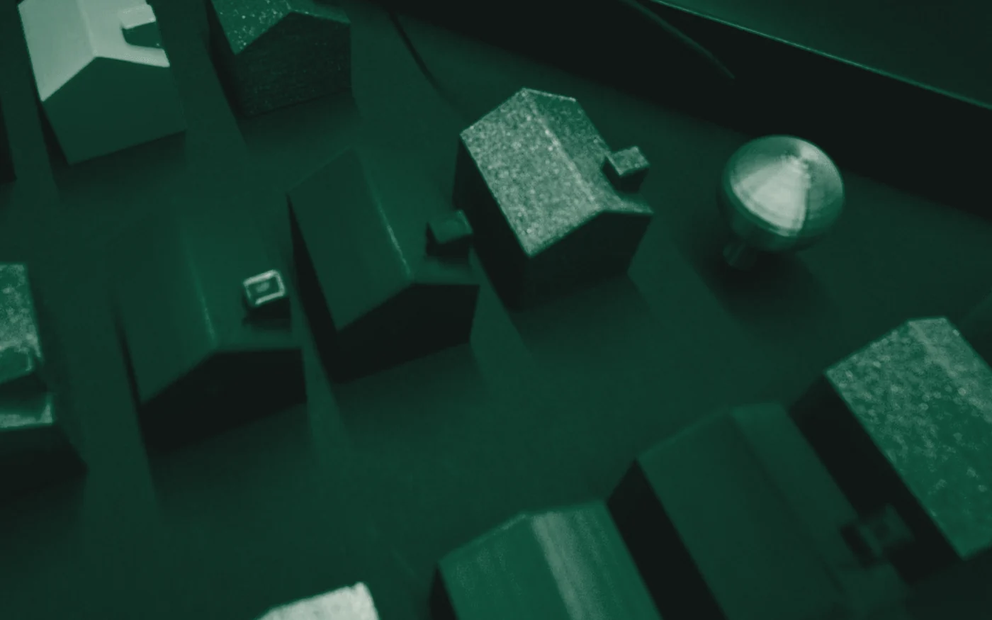 Maquetes de casas dispostas sobre uma superfície de trabalho, vistas de cima